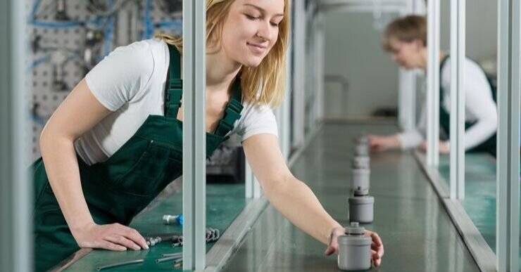 Employees working on a production line in a factory that uses a repetitive manufacturing system.